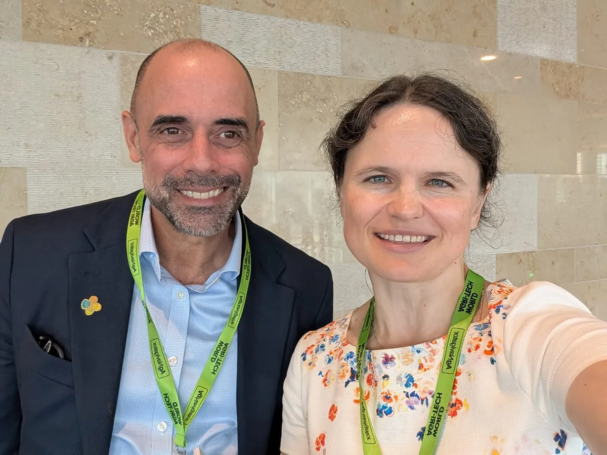 Dr. Maryna Kuzmenko in a selfie with Professor Mario Caccamo, in a dark jacket and open shirt, in front of a marble wall in the conference foyer.