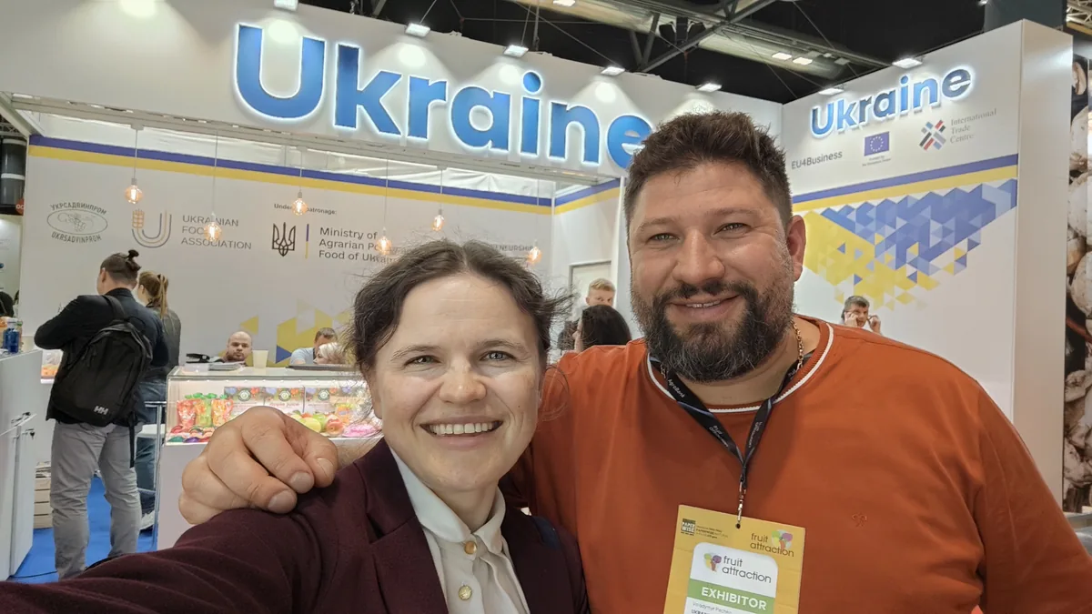 Dr. Maryna Kuzmenko in a selfie with Volodymyr Pechko in front of the Ukraine national stand at Fruit Attraction.